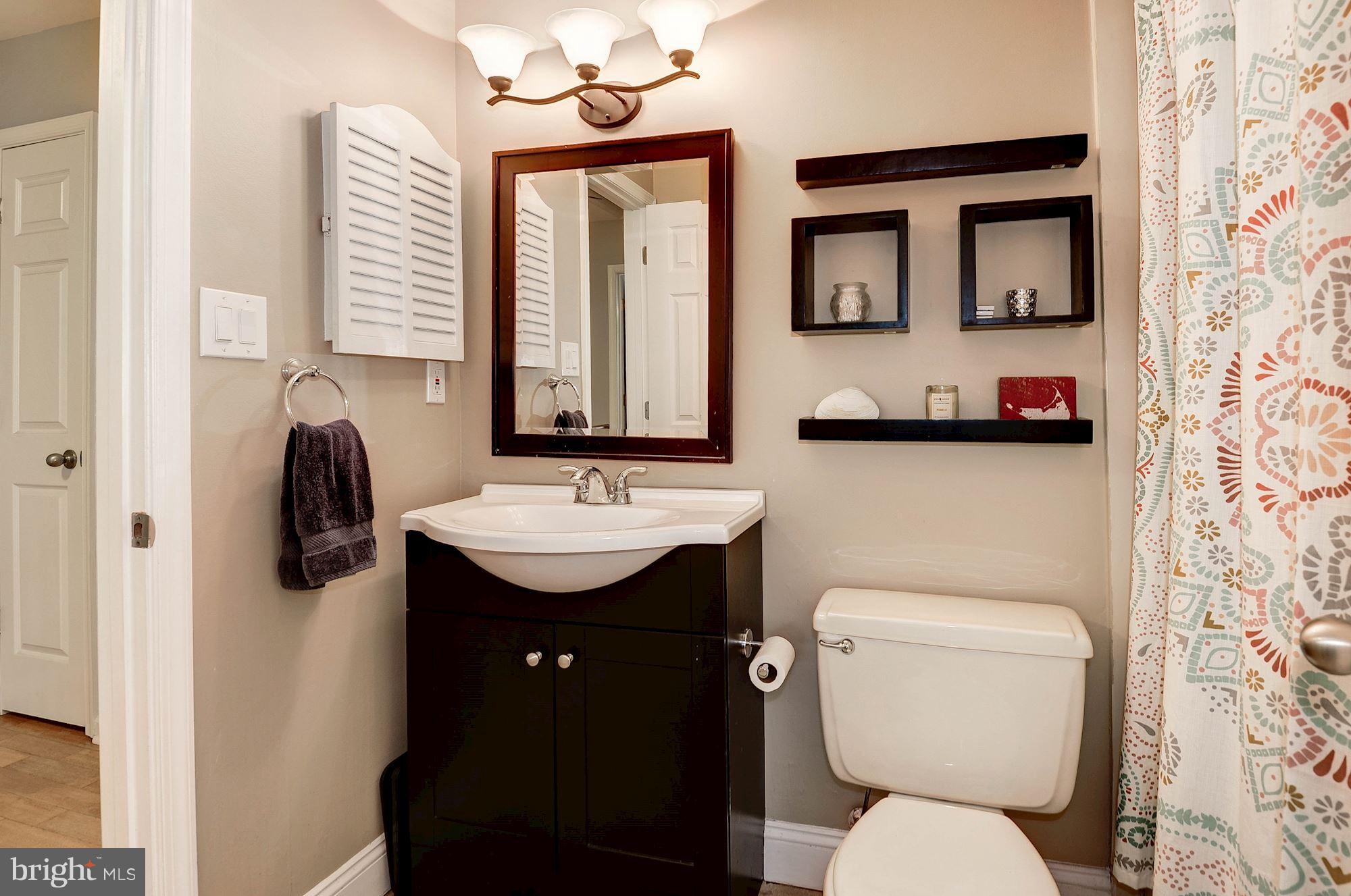 2546 South Walter Reed Drive, Unit 3 Arlington, VA 22206 - Photo 19 of 30 a bathroom with a toilet sink and mirror