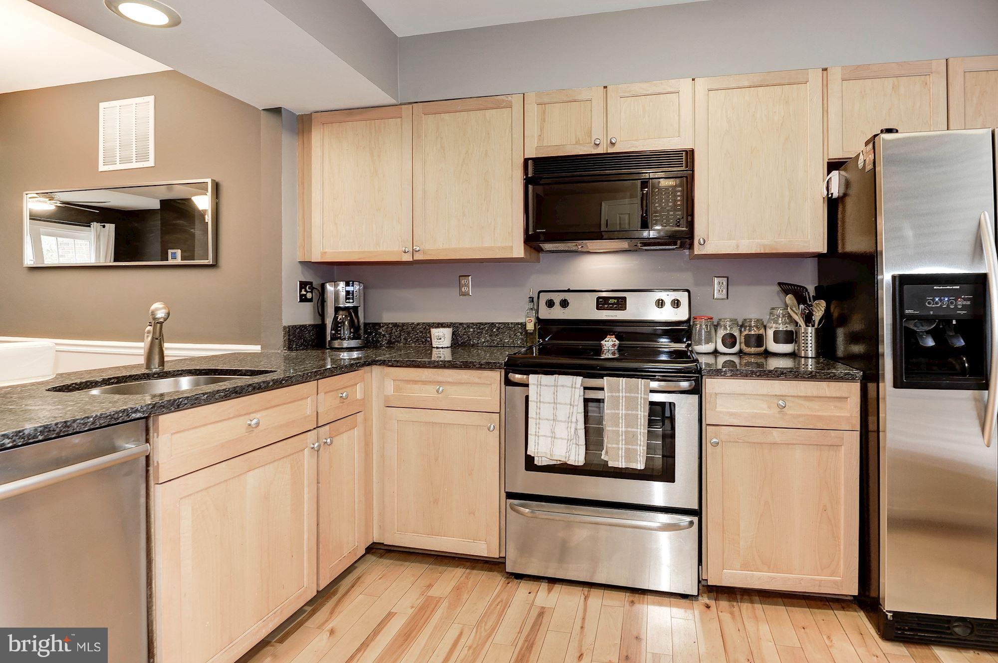 2546 South Walter Reed Drive, Unit 3 Arlington, VA 22206 - Photo 4 of 30 a kitchen with stainless steel appliances granite countertop a stove a sink and a microwave