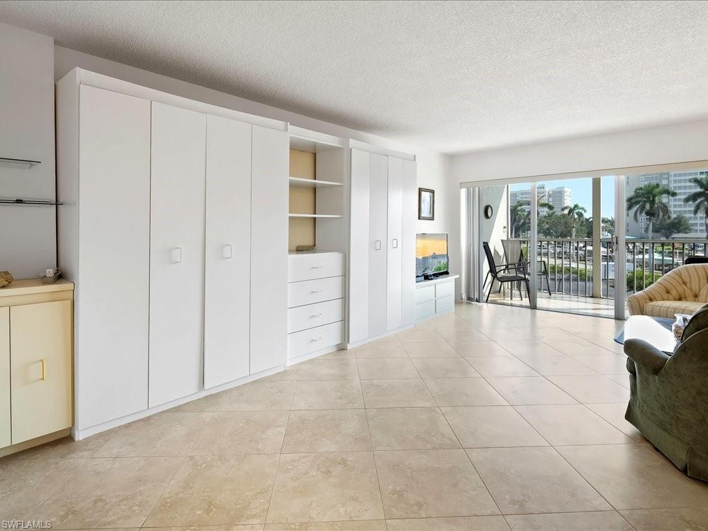 1 Bluebill Avenue, Unit 302 Naples, FL 34108 - Photo 3 of 21 wooden floor in an empty room with a window