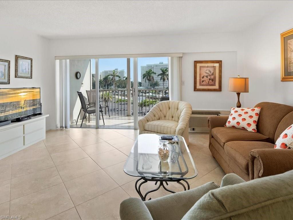 1 Bluebill Avenue, Unit 302 Naples, FL 34108 - Photo 5 of 21 a living room with furniture and a flat screen tv