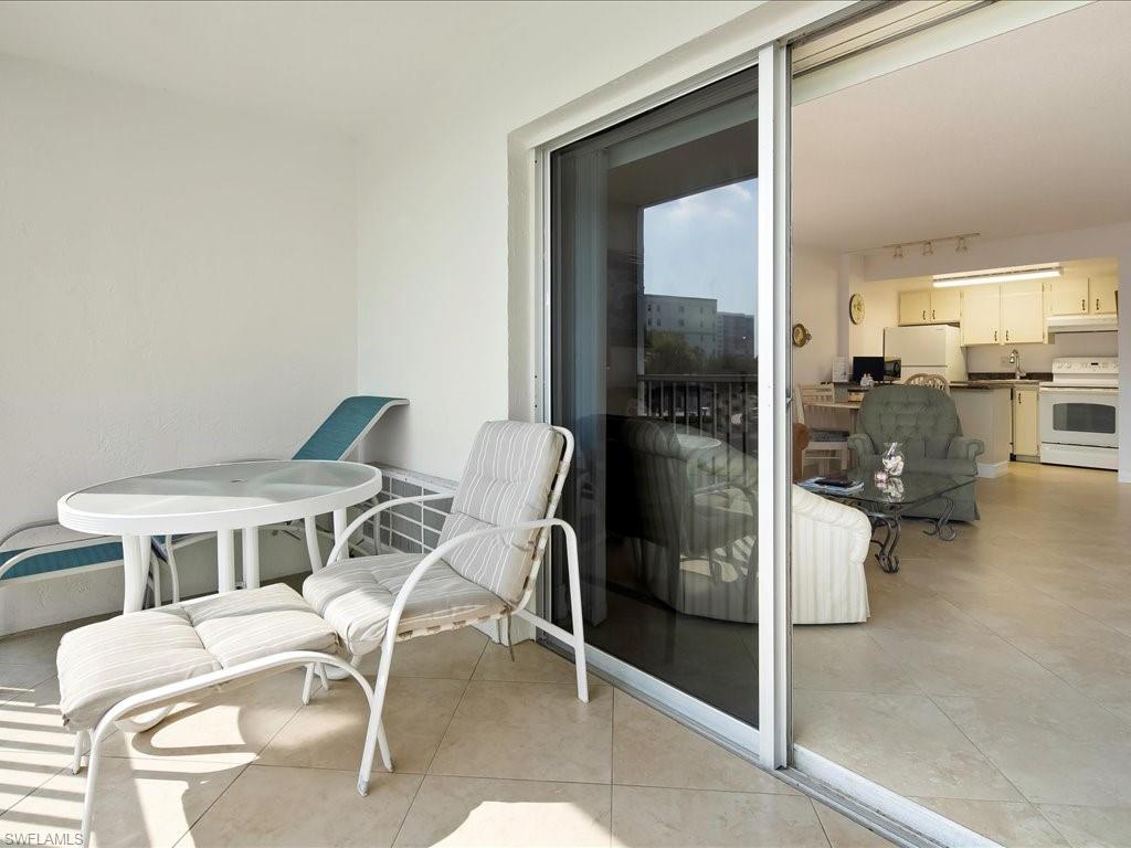 1 Bluebill Avenue, Unit 302 Naples, FL 34108 - Photo 7 of 21 a balcony with table and chairs