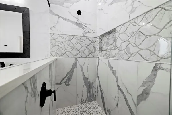 a bathroom with a sink and mirror with bathtub