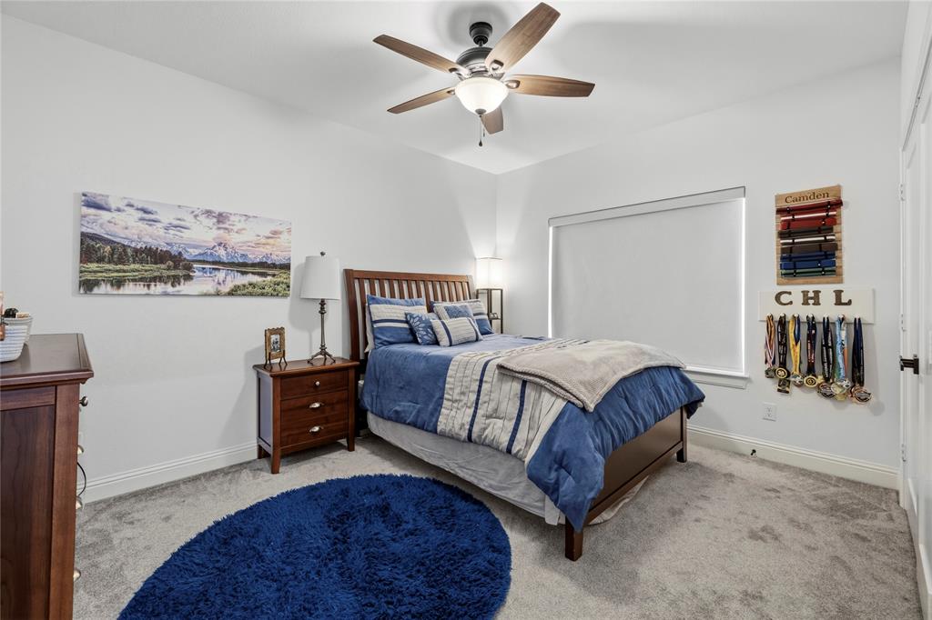 203 Colonial Drive Mabank, TX 75156 - Photo 24 of 36 a spacious bedroom with a bed and a chandelier