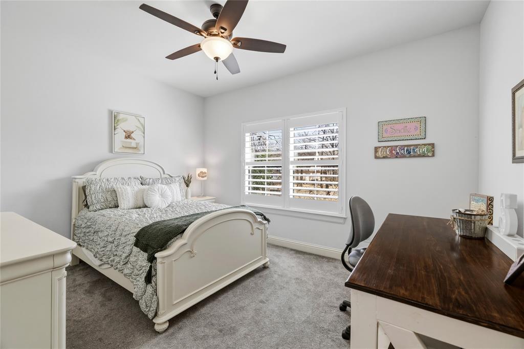 203 Colonial Drive Mabank, TX 75156 - Photo 27 of 36 a bed sitting in a bedroom next to a window with a chandelier