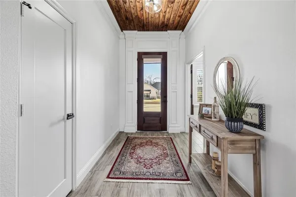 a view of a hallway with wooden floor and a potted plant