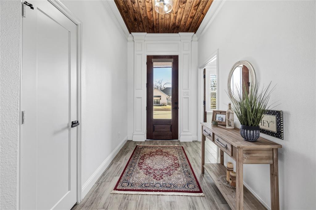 203 Colonial Drive Mabank, TX 75156 - Photo 3 of 36 a view of a hallway with wooden floor and a potted plant