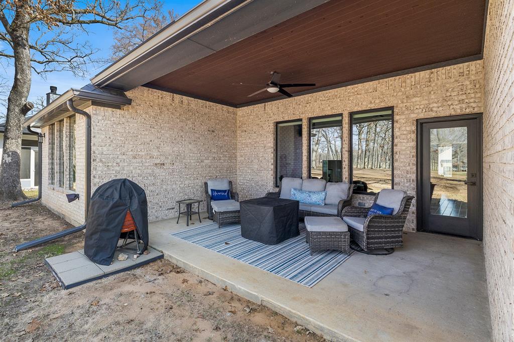 203 Colonial Drive Mabank, TX 75156 - Photo 32 of 36 a living room with furniture a wooden floor and a fireplace