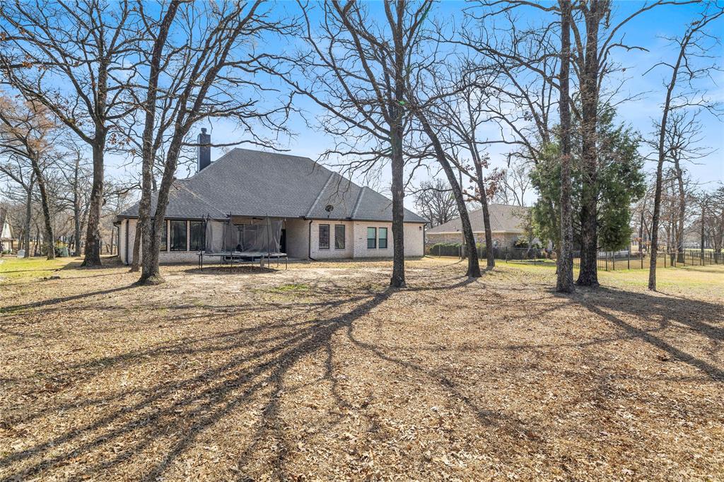 203 Colonial Drive Mabank, TX 75156 - Photo 34 of 36 a house with trees in front of it