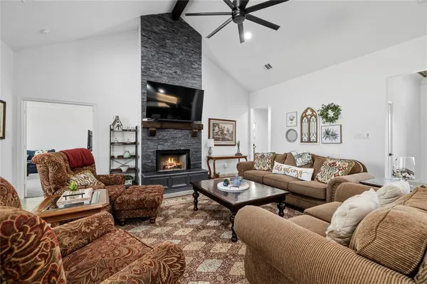 a living room with furniture a flat screen tv and a fireplace