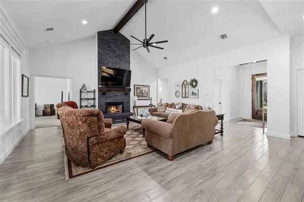 a living room with furniture a fireplace and a flat screen tv