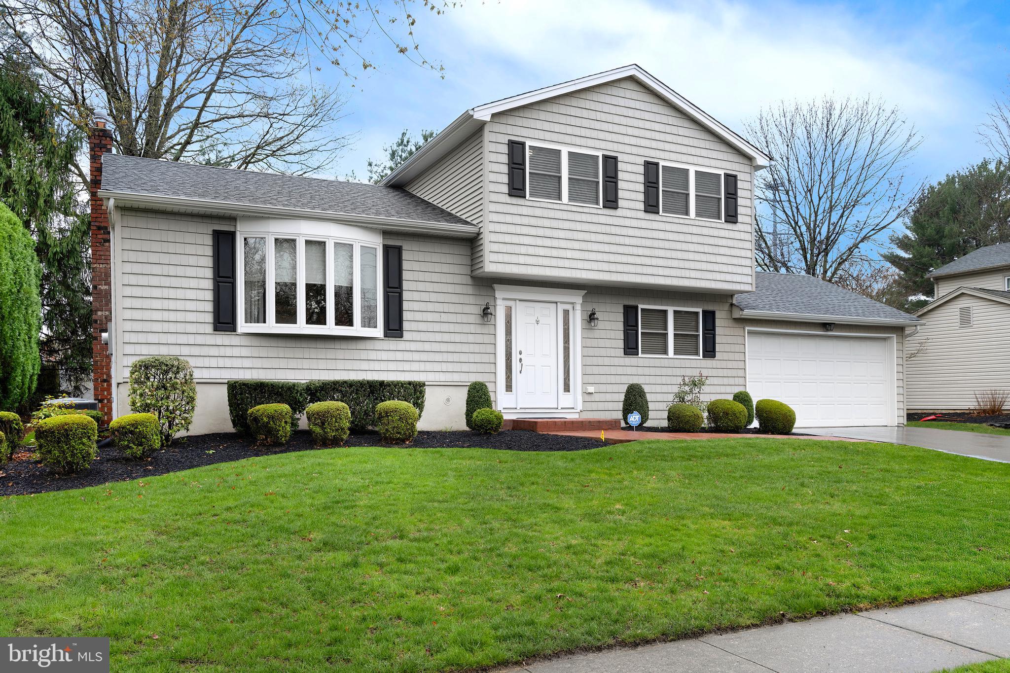 59 Wesleyan Drive Hamilton, NJ 08690 - Photo 3 of 25 a front view of a house with a yard and trees