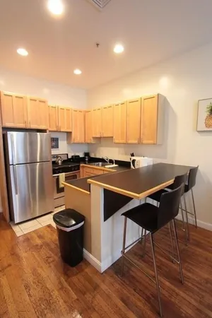 a kitchen with stainless steel appliances granite countertop a sink a stove a refrigerator and a microwave