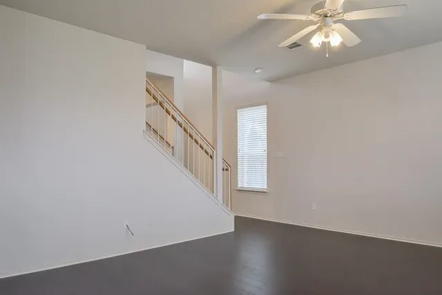 a large white kitchen with wooden floor and a window