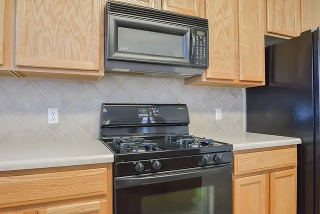 a kitchen with stainless steel appliances granite countertop a refrigerator stove top oven and sink