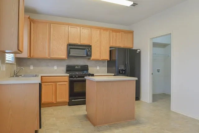 a stove top oven sitting inside of a kitchen
