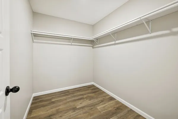 an empty room with wooden floor a ceiling fan and a window