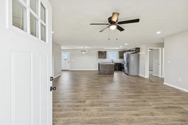 a view of an empty room with a window and wooden floor