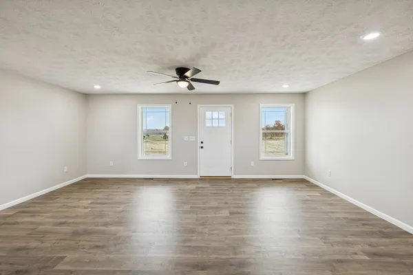 a view of empty room with wooden floor and fireplace