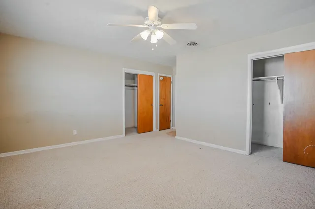 a view of an empty room with a ceiling fan