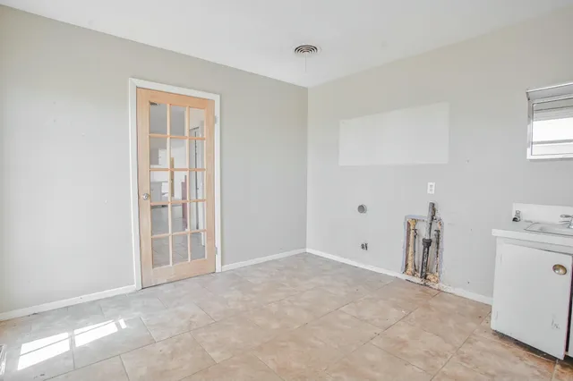 a view of empty room with window and cabinet
