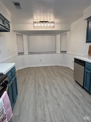 a view of a kitchen with wooden floor and electronic appliances