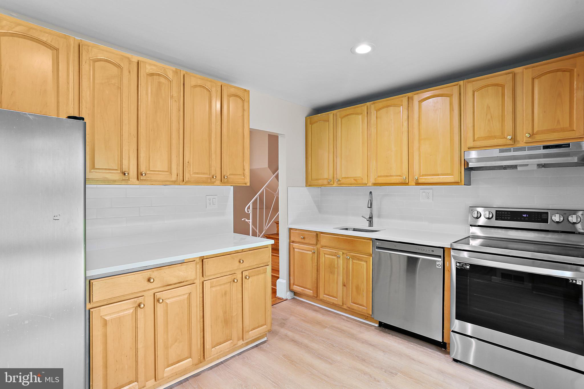 4113 Weller Road Silver Spring, MD 20906 - Photo 6 of 35 a kitchen with stainless steel appliances granite countertop white cabinets a sink and a stove