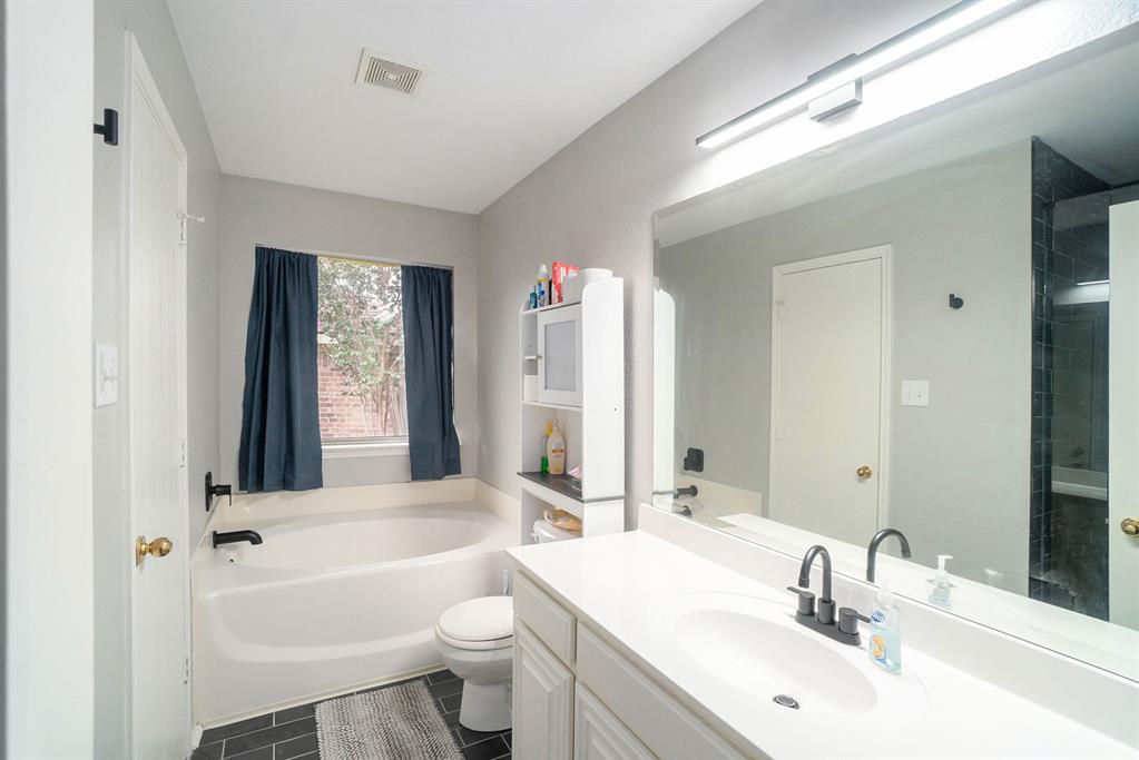 2808 Wakecrest Drive Fort Worth, TX 76108 - Photo 15 of 22 a bathroom with a bathtub a sink and a large mirror