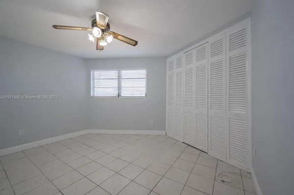 an empty room with chandelier fan