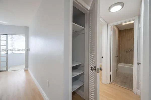 a bathroom with a walk in closet and wooden floor
