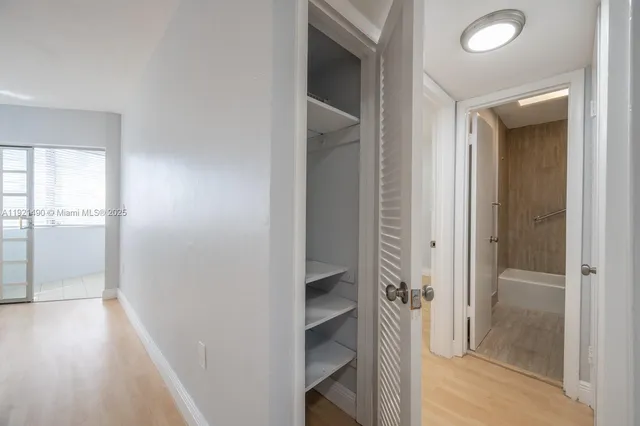 a bathroom with a walk in closet and wooden floor
