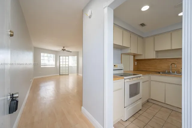 a kitchen with granite countertop white cabinets and white appliances