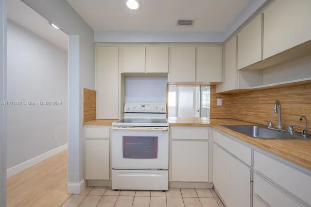 a kitchen with white cabinets and white appliances