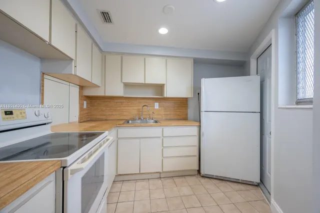 a kitchen with a refrigerator sink and cabinets