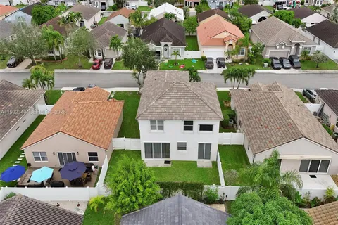 an aerial view of multiple houses with a yard