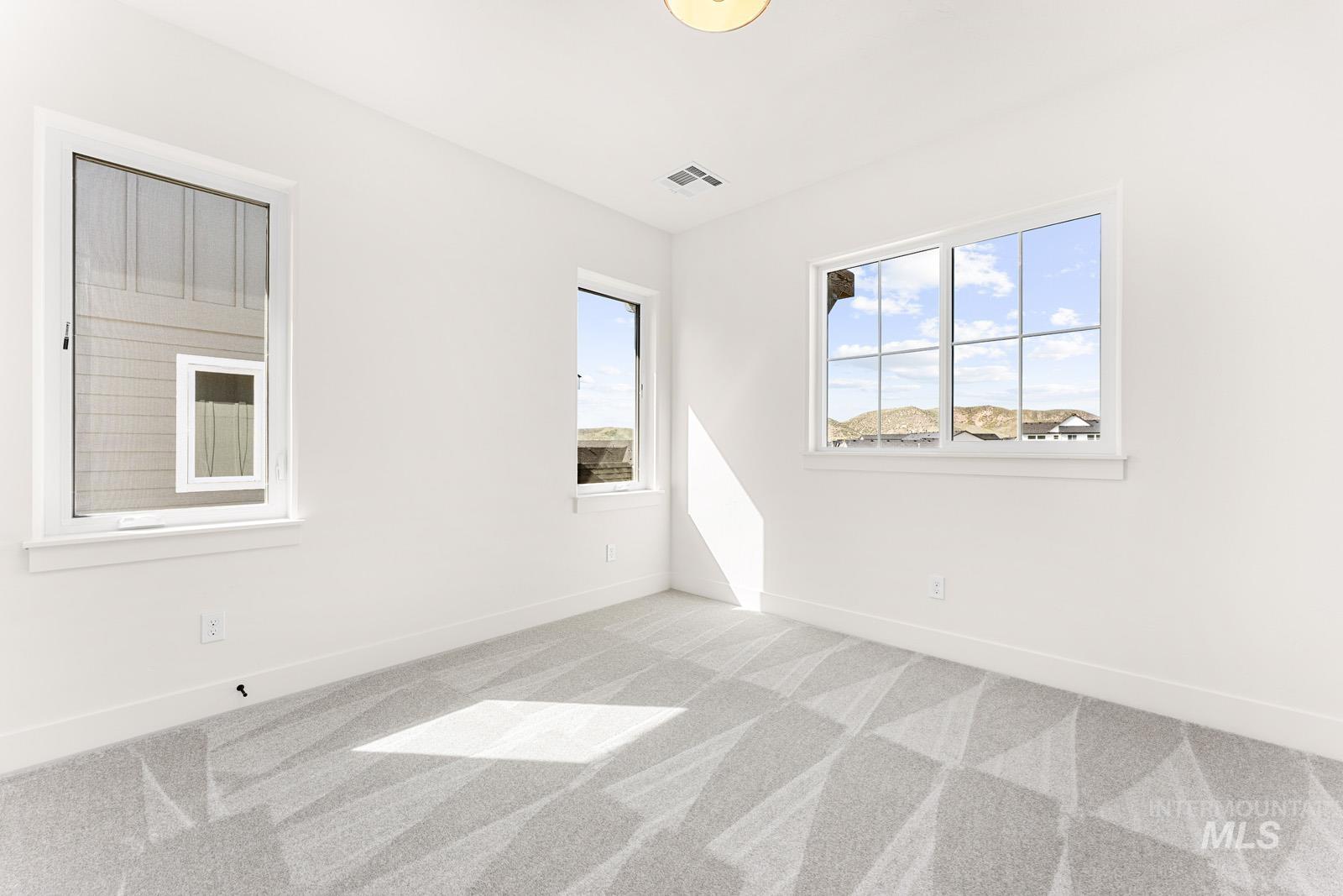 13344 North Spring Creek Way Boise, ID 83714 - Photo 21 of 39 Spare room featuring light carpet and baseboards