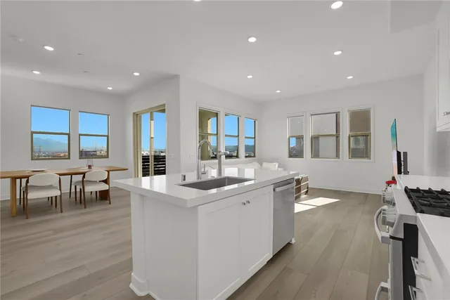 a kitchen with a table chairs and white cabinets