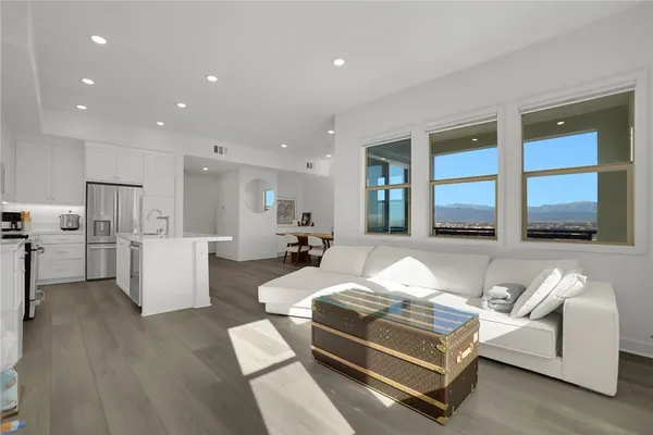 a living room with stainless steel appliances kitchen island furniture and a wooden floor