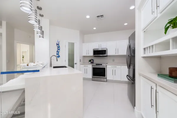 a kitchen with stainless steel appliances a stove sink and microwave