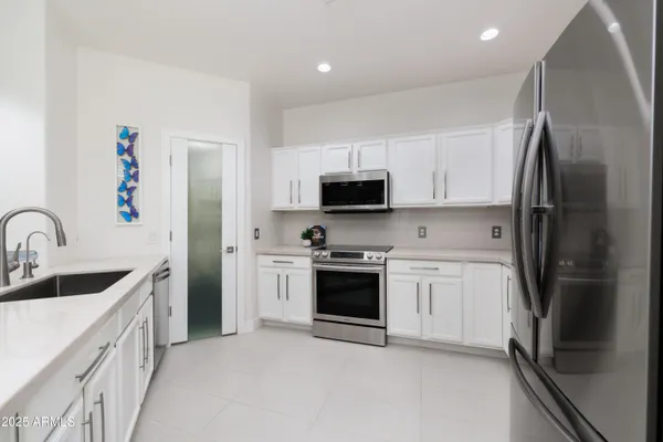 a kitchen with stainless steel appliances a refrigerator sink and microwave