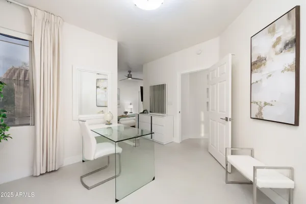 a living room with furniture and a painting on the wall