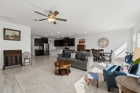 a living room with stainless steel appliances kitchen island granite countertop a sink cabinets and wooden floor