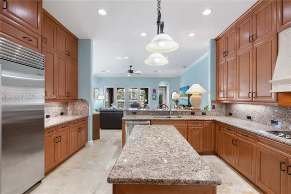 a large kitchen with kitchen island a large counter space a sink stainless steel appliances and cabinets