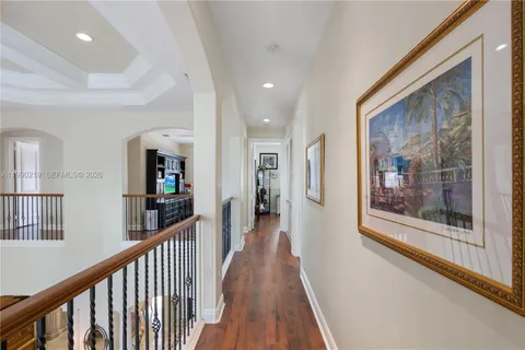 a view of a hallway with wooden floor and stairs