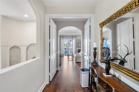 a view of a hallway with wooden floor and windows