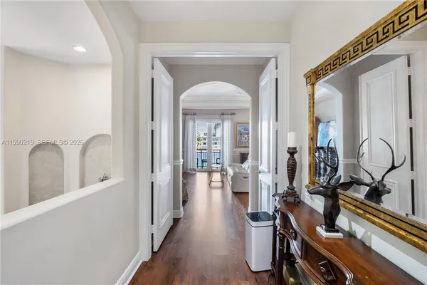 a view of a hallway with wooden floor and windows