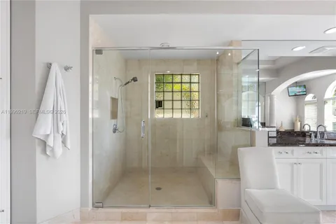 a bathroom with a shower a mirror and a sink