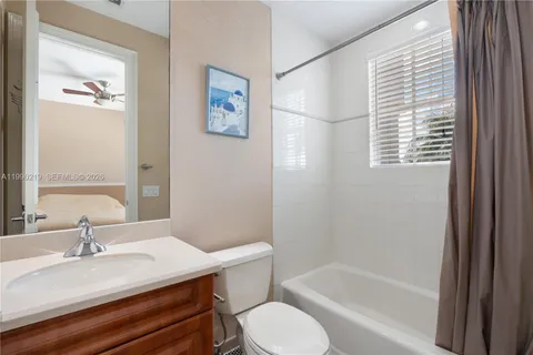 a bathroom with a granite countertop sink toilet and a bathtub