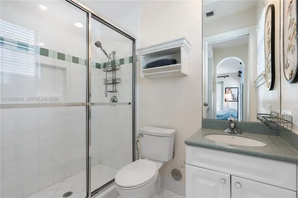 a bathroom with a granite countertop sink toilet and shower