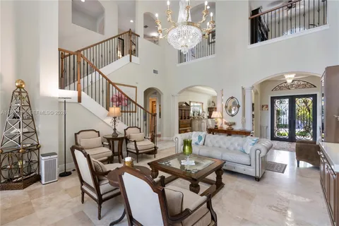 a living room with furniture flowers and a chandelier