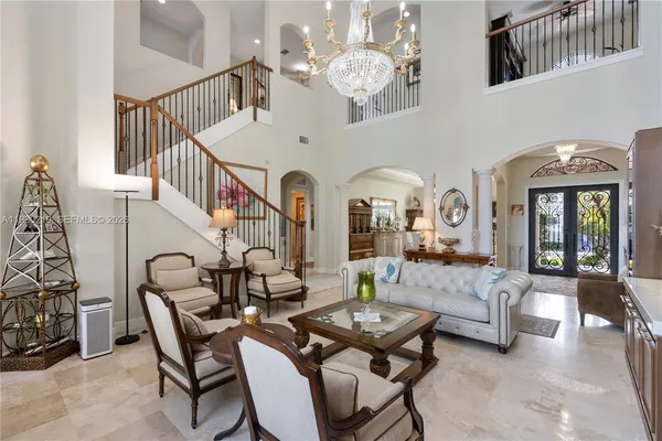a living room with furniture flowers and a chandelier